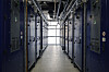Gang mellom parallelle rekker med serverskap i en opplyst serverhall.