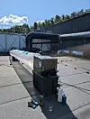 Aeroseal-utstyr koblet til en ventilasjonskanal på et flatt tak i solskinn.